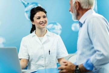 Dentist consulting with an older patient in a clinic.