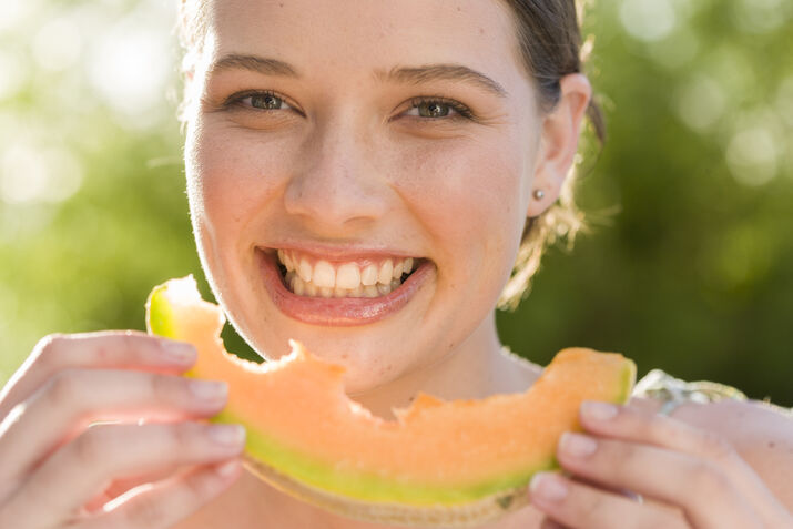 Portrait Smiling Woman Eating Melon Outdoors