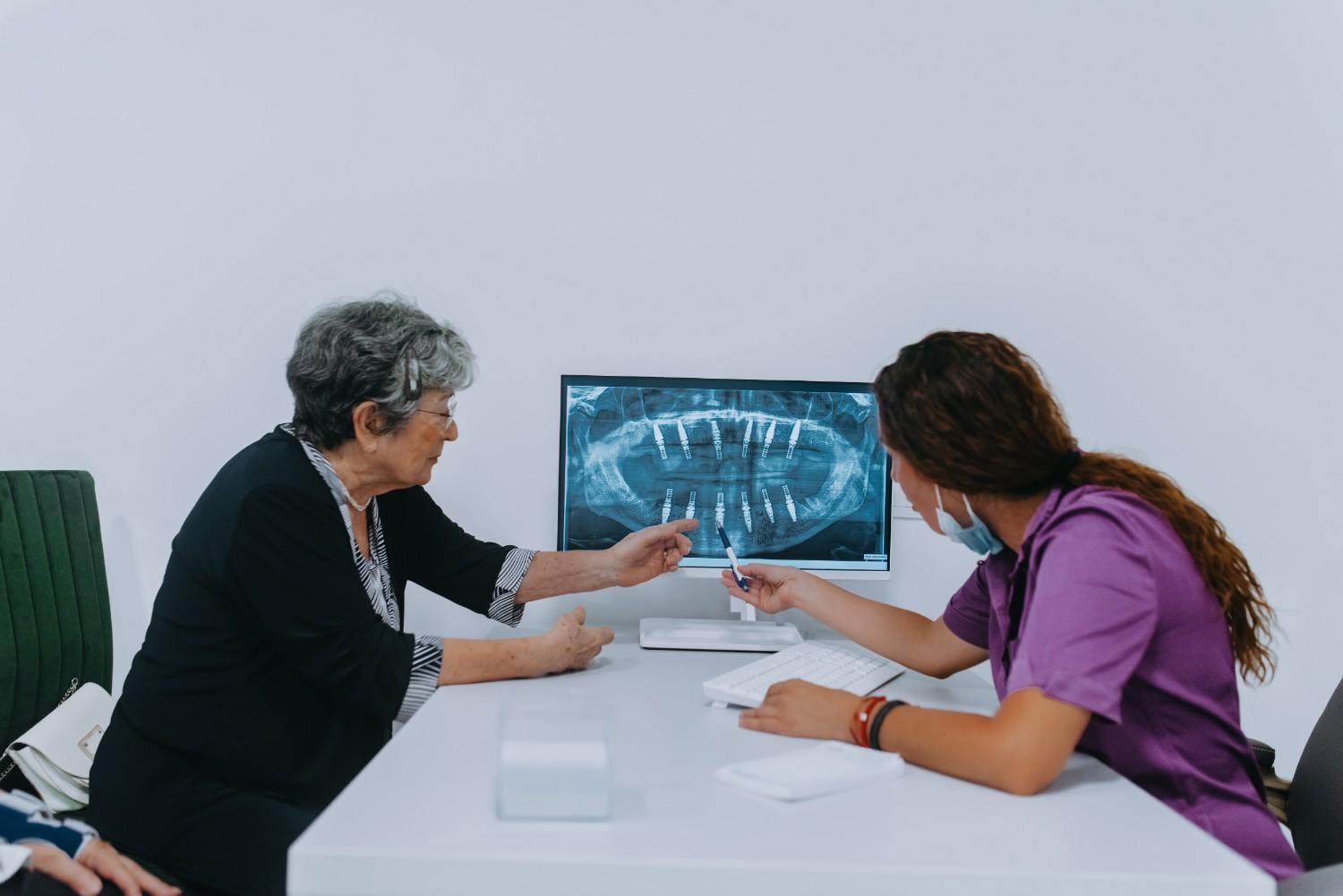 Dentist explaining a dental X-ray to an elderly patient.